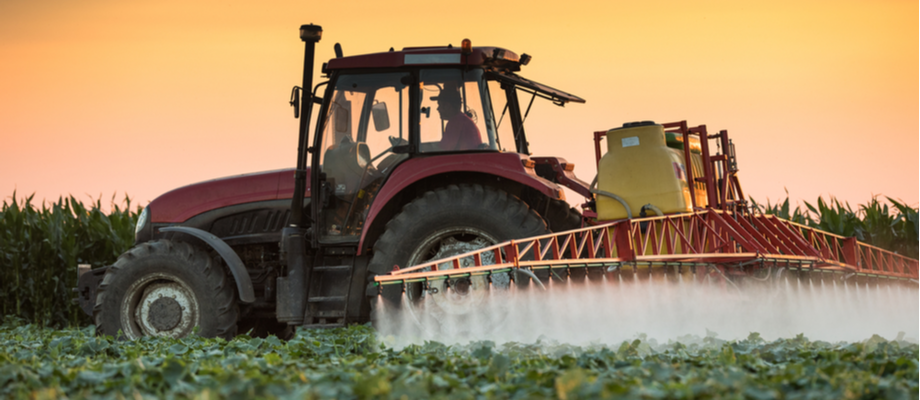 rociando plaguicidas en campo agrícola.