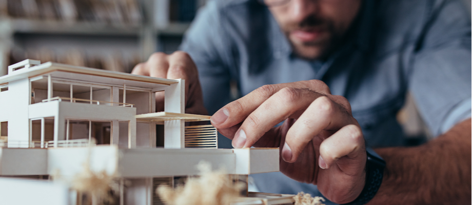 Arquitecto finalizando una maqueta de construcción sostenible.