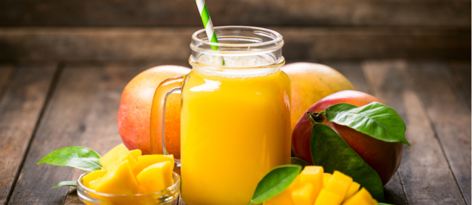 Jugo de mango y platos con trozos de mango fresco.