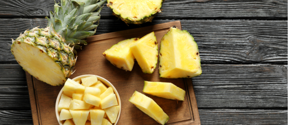 Mesa de madera con piña en trozos.