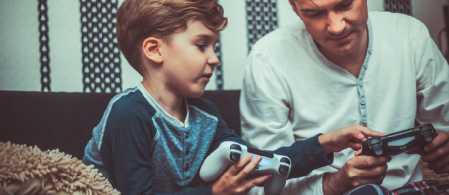 Niño y adulto jugando videojuegos.